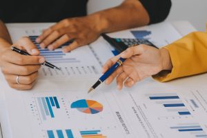 Financial analysts analyze business financial reports on a digital tablet planning investment project during a discussion at a meeting of corporate showing the results of their successful teamwork.